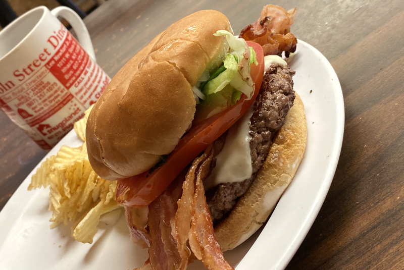 Bacon cheeseburger and fries on a diner plate